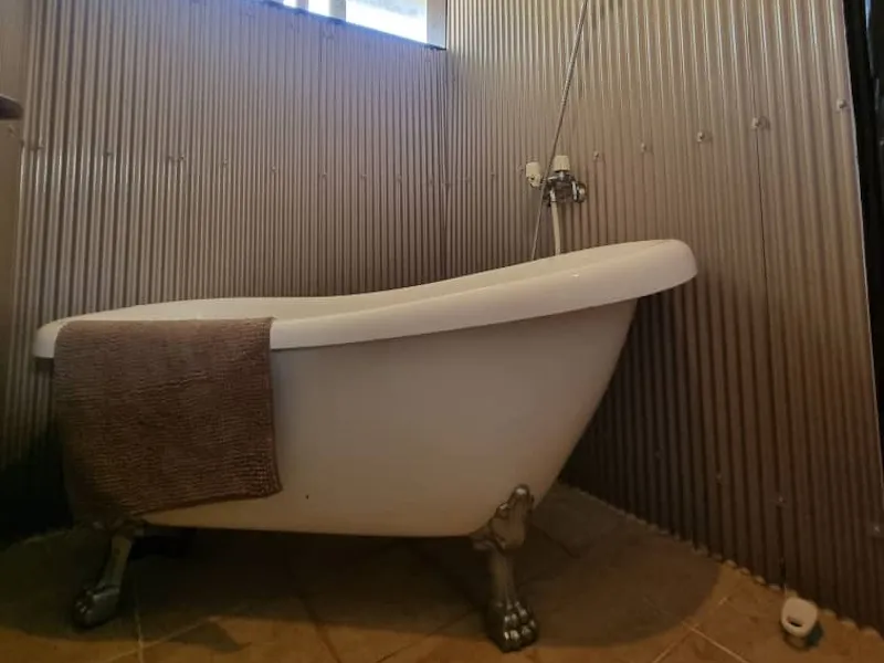 Clawfoot bathtub against corrugated metal walls