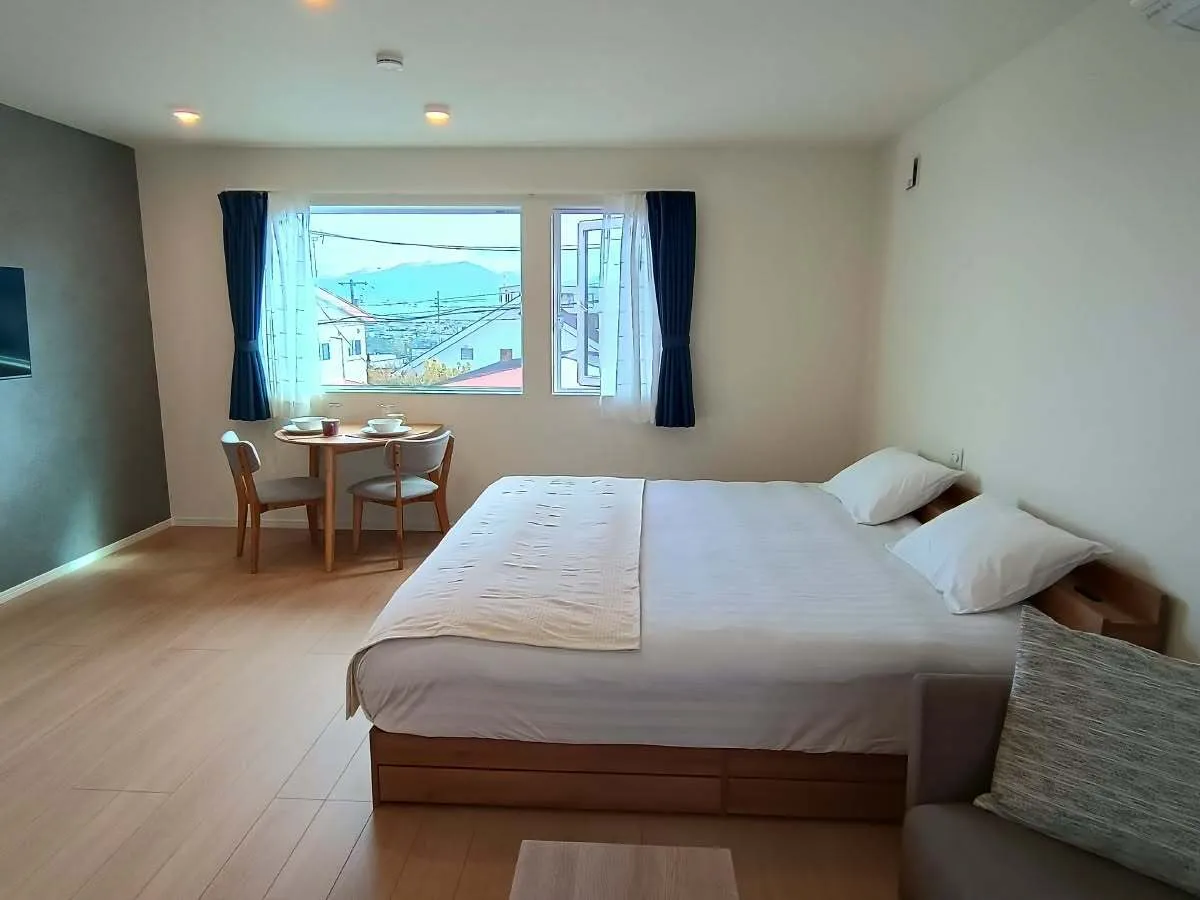 King bed with wall-mounted TV in the King or Twin Studio Apartment