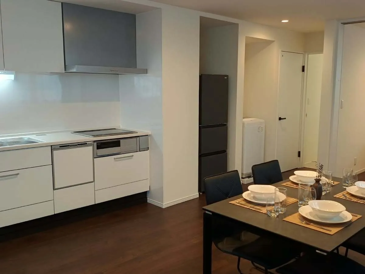 Modern kitchen with dining table, fridge and washing machine alcove