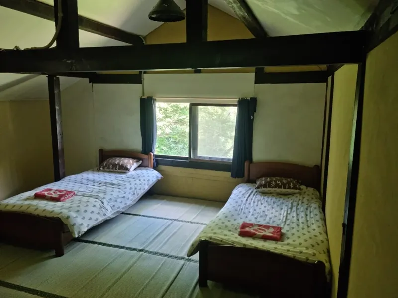 Loft bedroom with exposed beams and two single beds