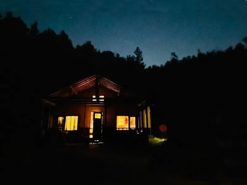 Bears House glowing under a starry night sky