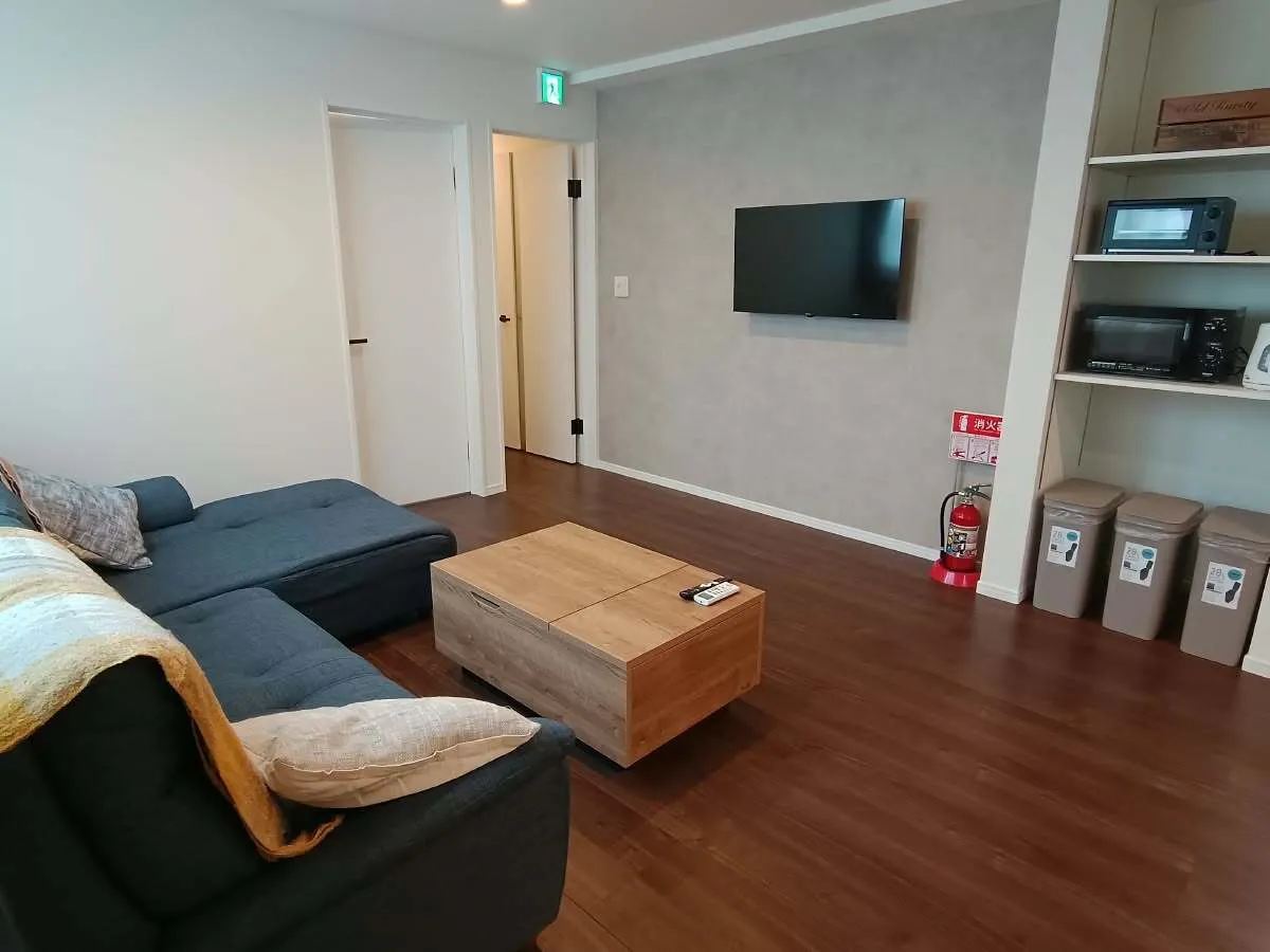 Open-plan living area with wall-mounted TV and kitchen