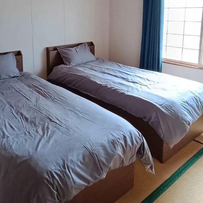 Tatami bedroom with twin beds and blue curtains