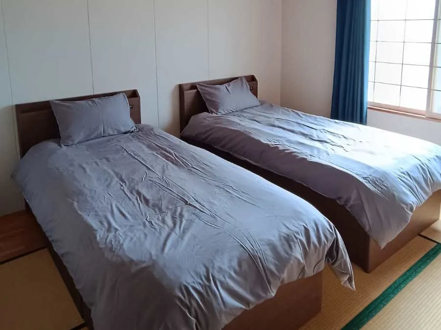 Tatami bedroom with twin beds and grey linen