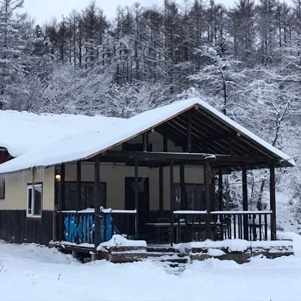 Bears House in winter, snow-covered porch surrounded by frosted forest